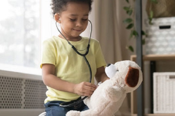 Child using a stethoscope on a teddy