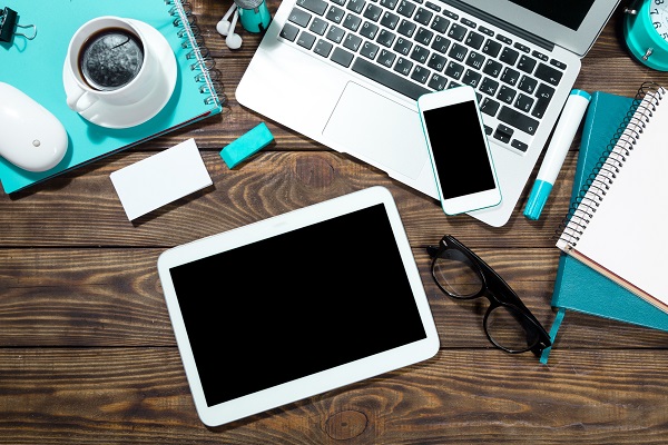 Mobile, tablet and laptop on a desk with a cup of coffee